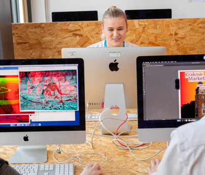 student working on graphics on macs in classroom