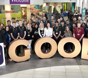 large group of people stood behind large gold letters spelling GOOD and Ofsted Good Provider signs