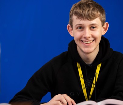 Sixth form student smiling to camera with open book