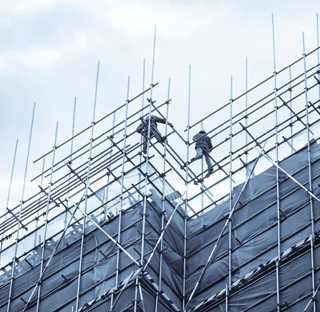 workmen in harnesses on scaffolding