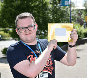 Callum Duxbury holding golden envelope