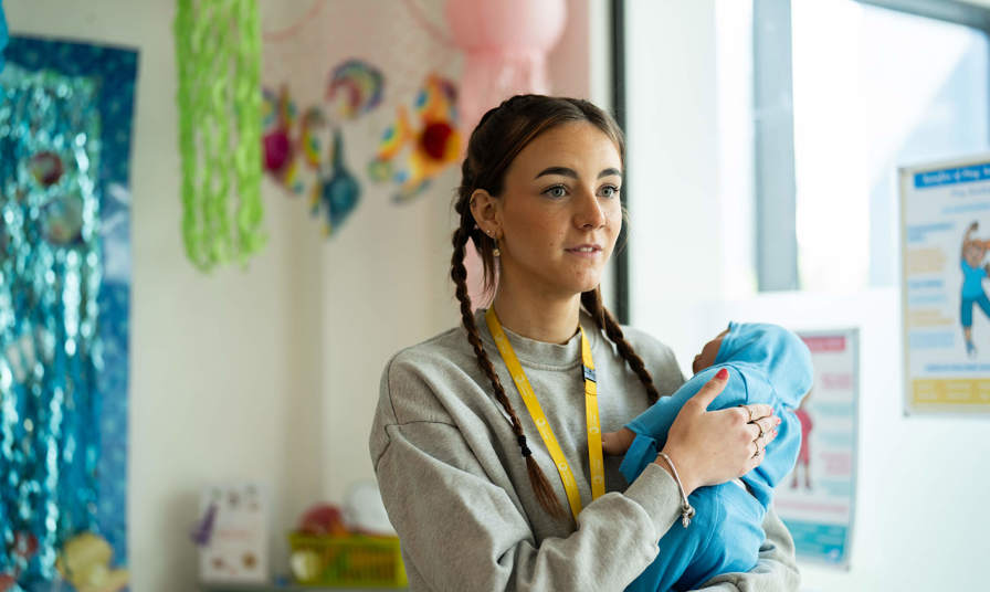 Young girl holding a practice baby doll