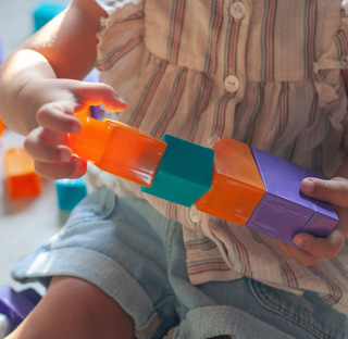 close up of child playing with plastic blocks